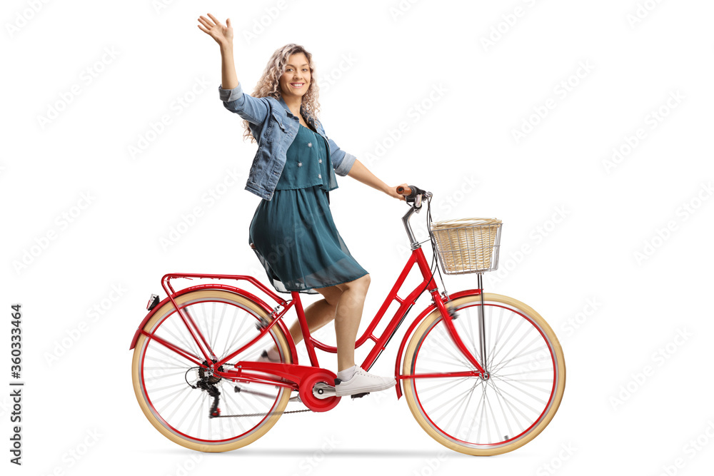 Young woman riding a red bicycle and waving Young woman riding a red bicycle and waving