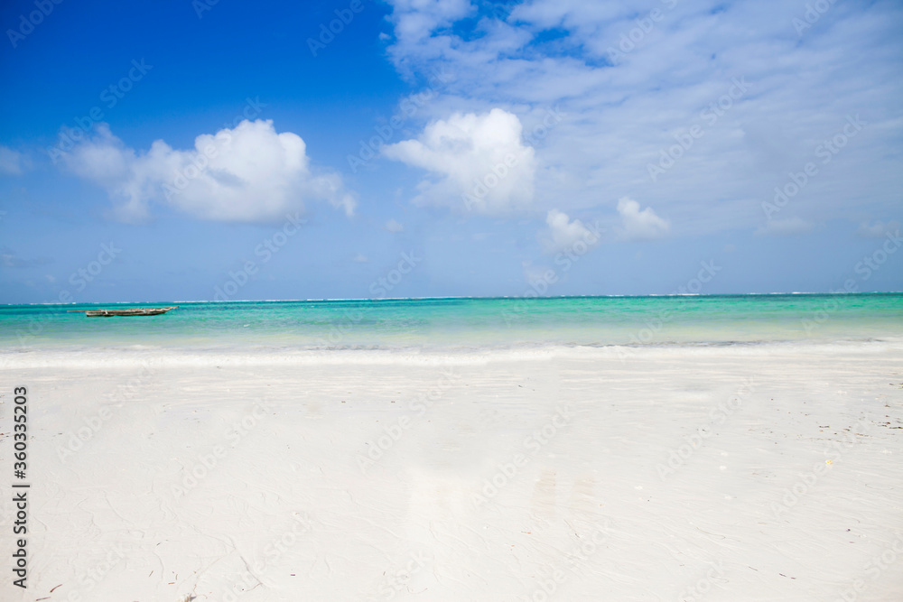 Clean white sand beach with turquoise water . Tropical island background. Small waves crushing on the beach. Beautiful clouds against blue sky Clean white sand beach with turquoise water . Tropical island background. Small waves crushing on the beach. Beautiful clouds against blue sky