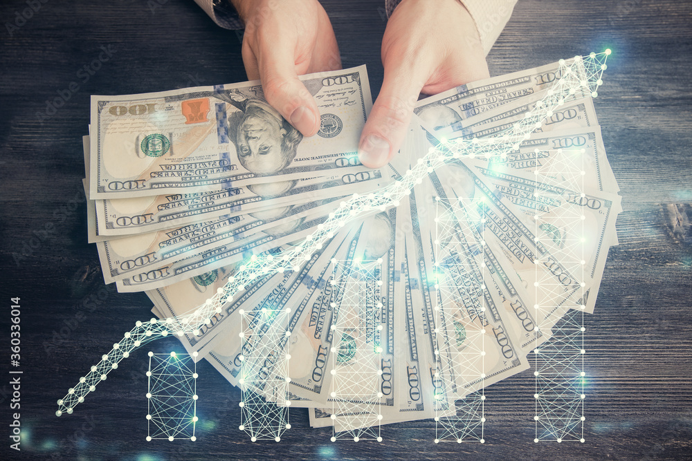 Multi exposure of financial graph drawing hologram and USA dollars bills and man hands. Analysis concept. Multi exposure of financial graph drawing hologram and USA dollars bills and man hands. Analysis concept.