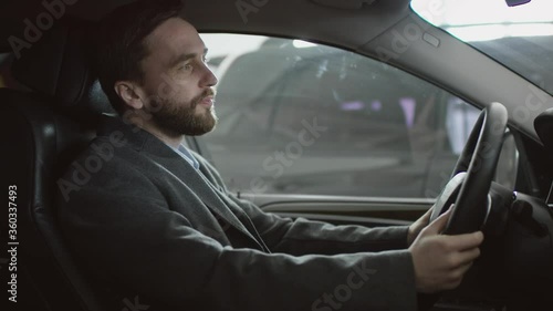Driving car handsome man sitting in the car on a driver's seat and honking in the car. Businessman shouting hile sitting in a car.