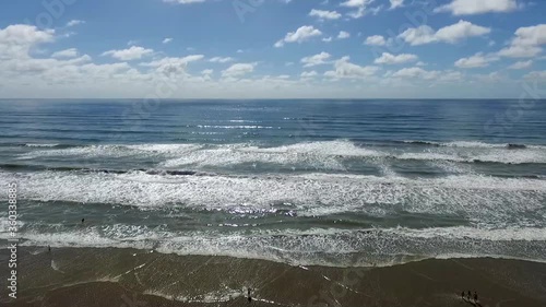 Aerial view of waves breaking on the beach. Flying over the beach and the sea with a drone. Atlantic ocean, Argentina.
