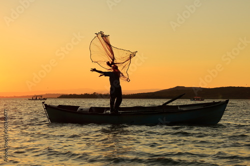 Fishing on the boat at sunset. © Suat