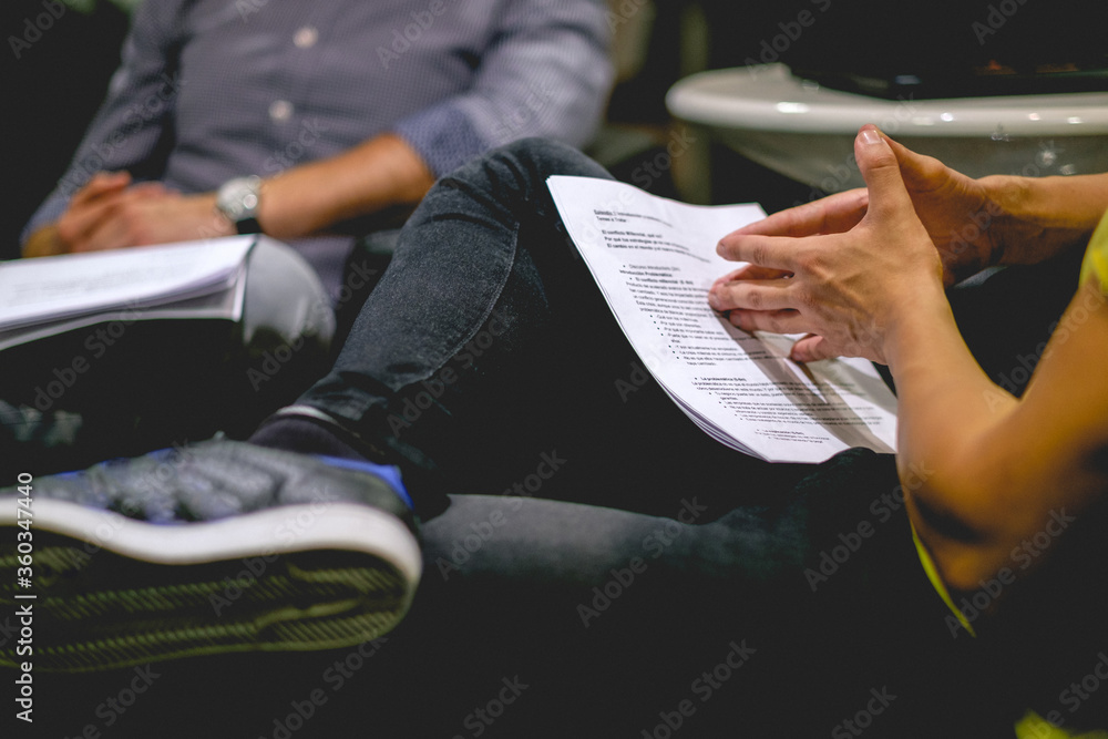 Men with crossed legs and sneakers shoes reading a papers on a business meeting