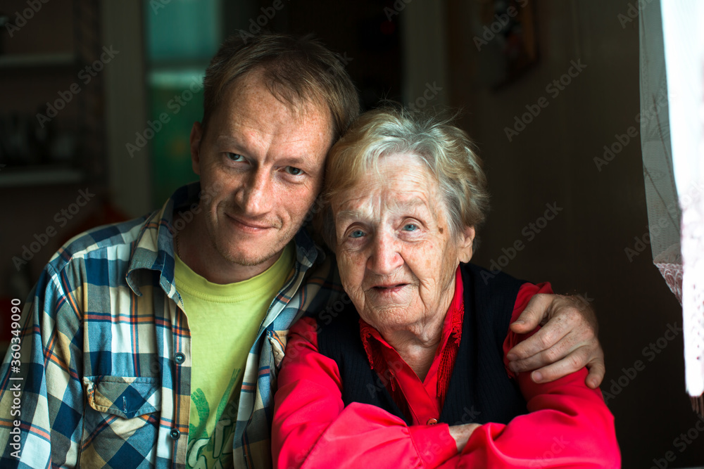 Portrait of a man embracing his grandmother.