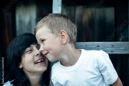 Small funny boy with sister, close-up portrait. The village children outdoors.