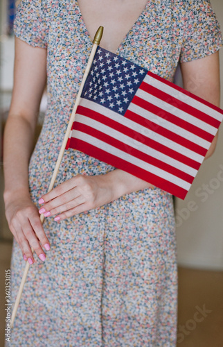 young girl holding the flag of the united states of america in her hands