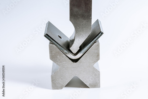 Sheet metal bending tool and equipment isolated on a white background. Bend tools, press brake punch and die. photo