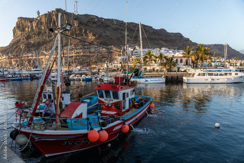 fishing boat at sunset in the harbor of puerto mogan, gran canaria, spain