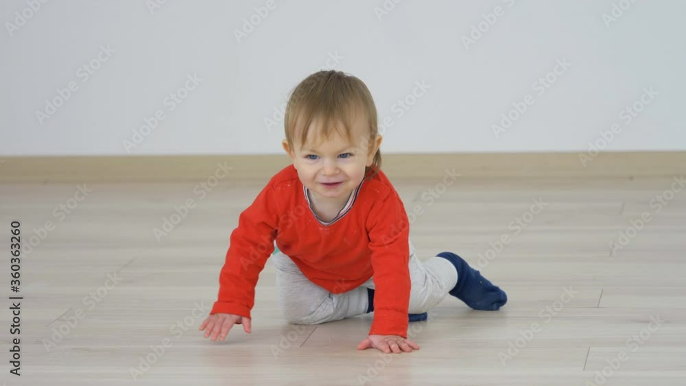 Lovely baby child sit and go crawling on floor, independent sweet smile Lovely baby child sit and go crawling on floor, independent sweet smile