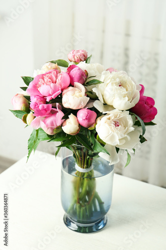 Bouquet of beautiful peonies in vase on white table © New Africa