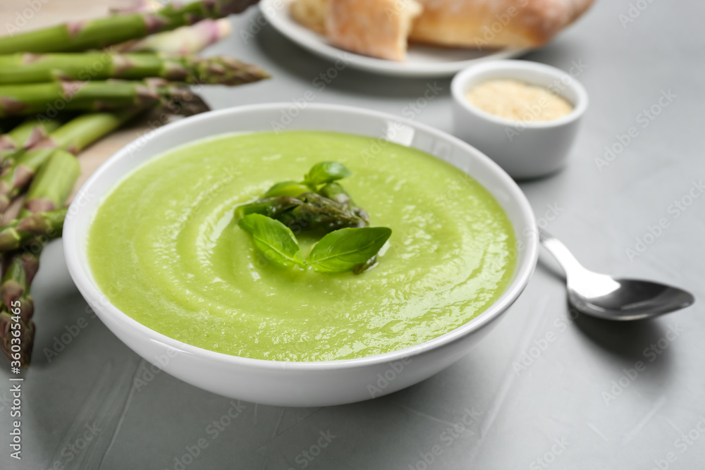 Delicious asparagus soup served on grey table, closeup Delicious asparagus soup served on grey table, closeup