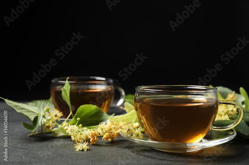 Tasty tea and linden blossom on black table. Space for text
