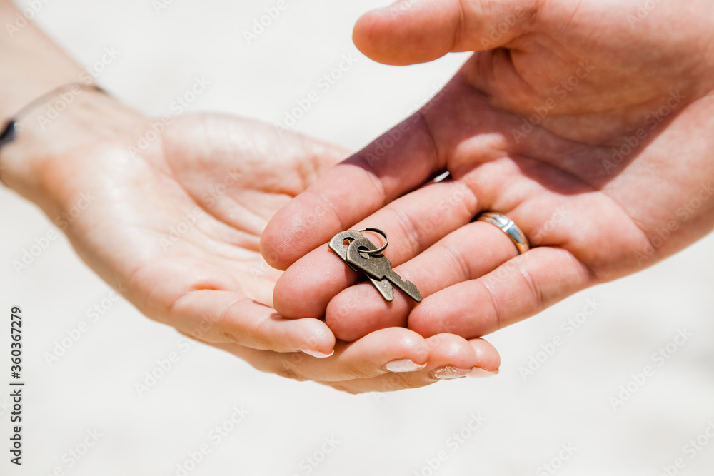 Newlyweds bride and groom holding in hands a locked padlock heart shaped, made from metal, color gold.Unity symbol, love and family concept. Wedding tradition. 