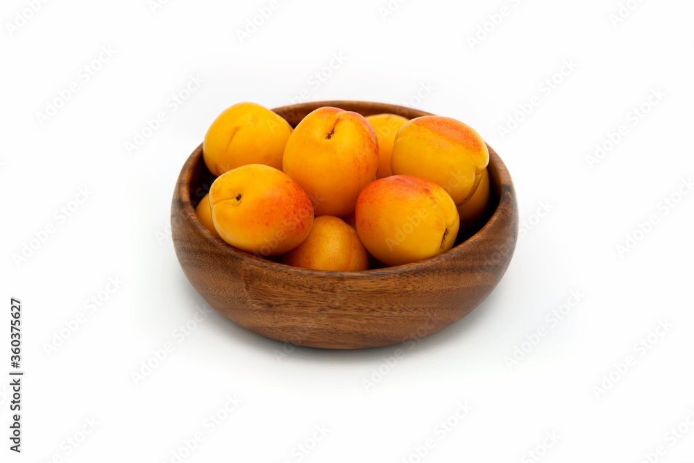 apricots on a wooden plate on white background apricots on a wooden plate on white background