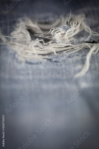 Close up detail of old torn denim jean, shallow depth of field 