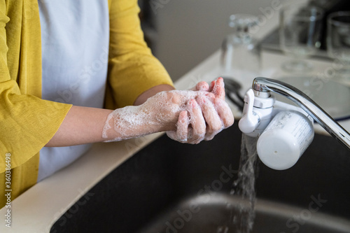 キッチンで手洗いをする女性の手元 