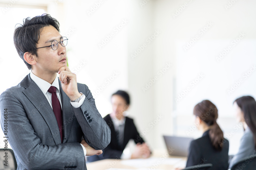 会議室で悩むビジネスマン 会議室で悩むビジネスマン