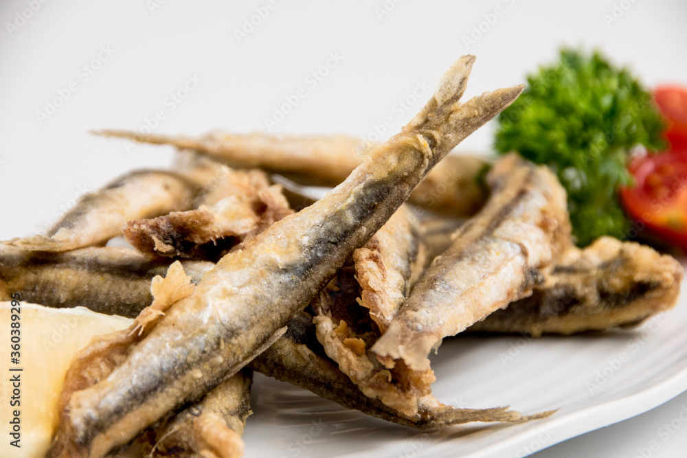 A plate of sardines on a white background A plate of sardines on a white background