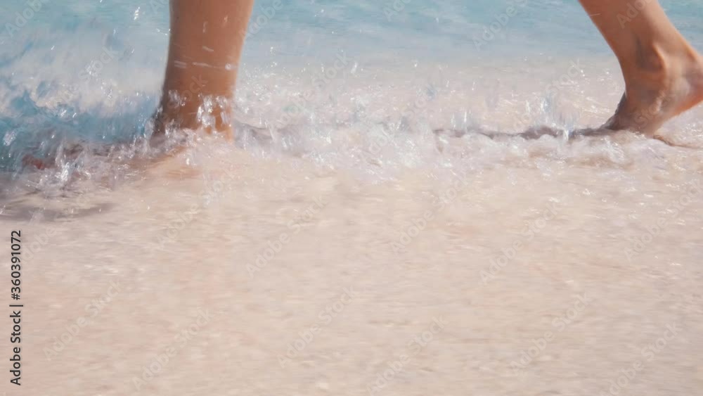 Girl walking on the pink beach, feet in the sea. Girl walking on the pink beach, feet in the sea.
