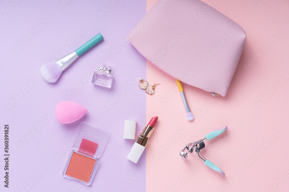 Top view - Cosmetic make up collection set over purple and pink background. Top view - Cosmetic make up collection set over purple and pink background.