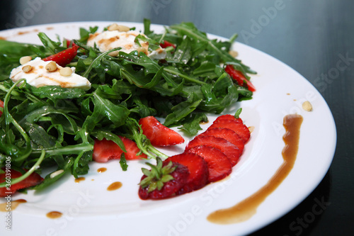 Salad with arugula, cream cheese and strawberries. Salad with arugula and strawberries. Rucola and strawberries.