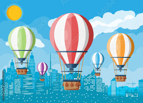 Hot air balloon in the sky with clouds and sun. Vintage air transport. Cityscape background. Aerostat with basket. Flat vector illustration