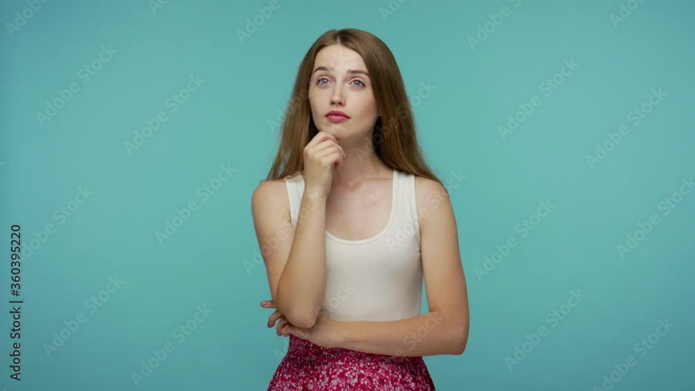 Happy inspired girl thinking with meditative positive expression, raising finger with invented great idea solution, know answer, genius plan, creative thought. studio shot isolated on blue background