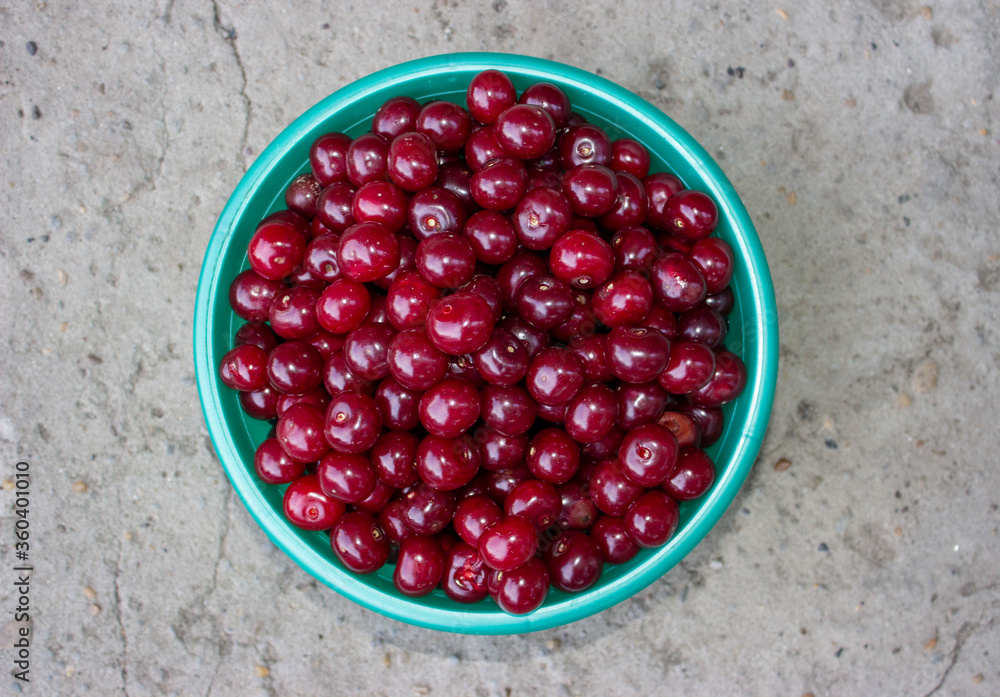Red cherry, large. A full Cup of ripe berries. Merry.Gray background.