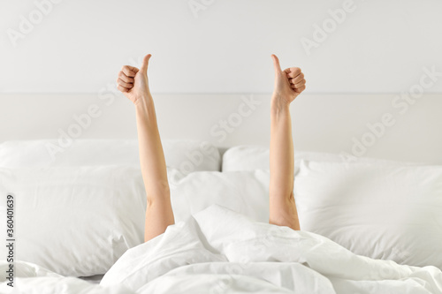 фотографія gesture, comfort and morning concept - hands of young woman lying in bed and sho