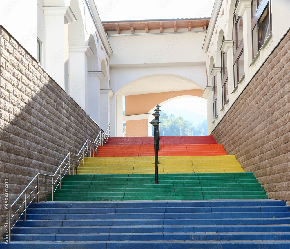 Beautiful staircase with steps of different colors, handrails for the disabled, social stairs