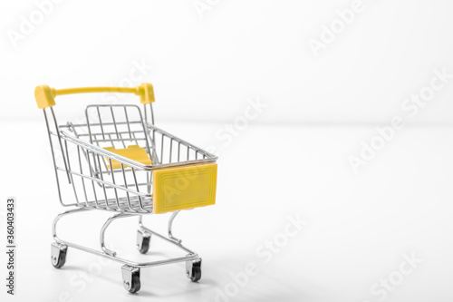 Shopping cart on white background, Empty metal shopping cart or trolley on white viewed sideways conceptual of shopping, consumerism, retail and e-commerce