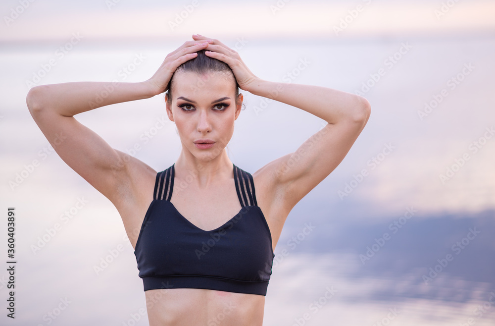 portrait of a beautiful fitness model on a background of the sea at sunset portrait of a beautiful fitness model on a background of the sea at sunset
