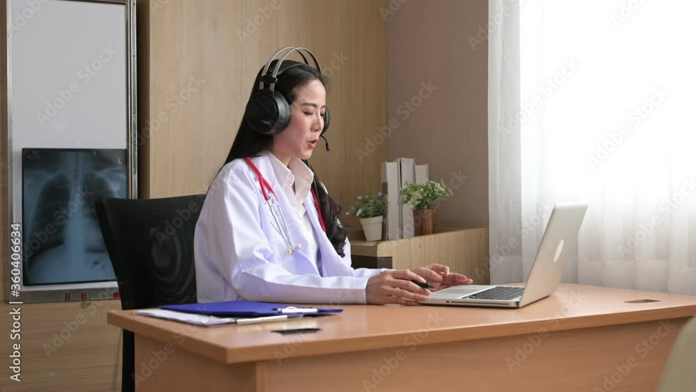 An Asian doctor is introducing his patients via an online video conference. New normal and social distancing for healthy consult concept. An Asian doctor is introducing his patients via an online video conference. New normal and social distancing for healthy consult concept.