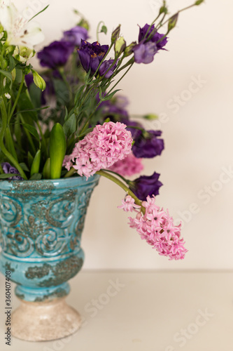 Bouquet of pink hyacinthus and purple lisianthus in a turquoise