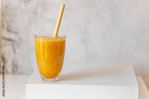Tasty peach smoothie in glass on white table