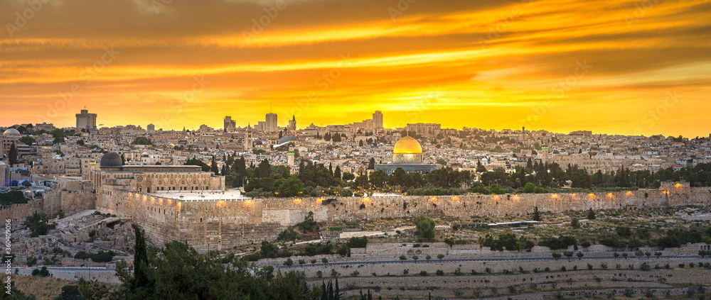 Beautiful panoramic view of Jerusalem - Old and New City, with the Dome of the Rock and the Temple Mount, south-east wall corner with Hulda Gates archaeological site and dramatic orange sunset sky