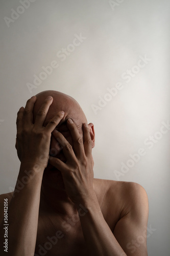 両手で顔を覆う男