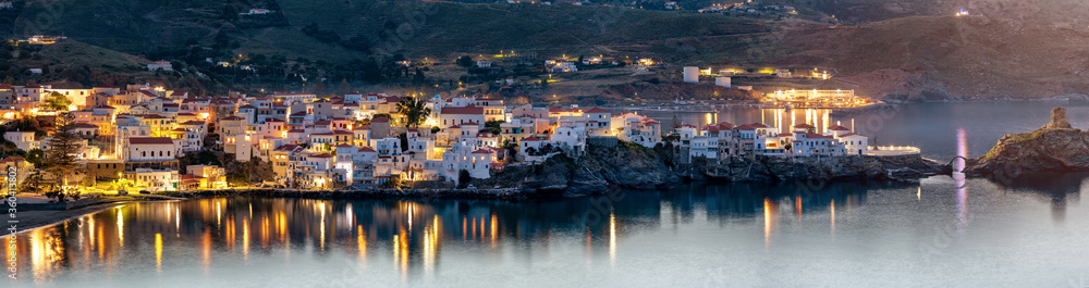 Panoramablick auf die beleuchtete Stadt von Andros, Kykladen, Griechenland, bei Dämmerung
