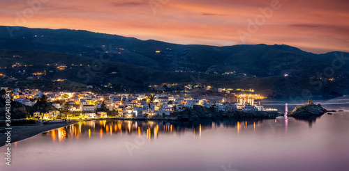 Schönes Panorama der Bucht von Andros mit Stadt und Hafen während eines Sommer Sonnenunterganges, Kykladen, Griechenland