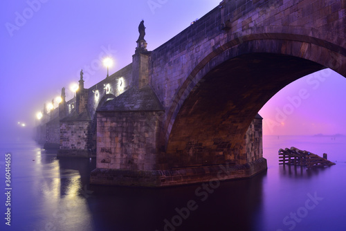 Charles Bridge in Prague Old Town on Vltava River. Early morning. Heavy fog.