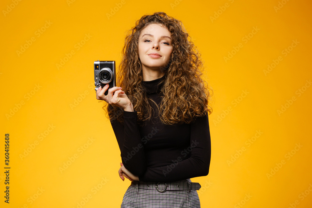 Beautiful girl with photo camera isolated on yellow background Beautiful girl with photo camera isolated on yellow background