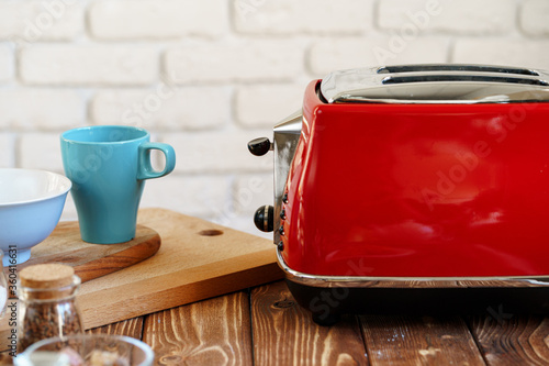 Close up photo of a red toaster on a kitchen table