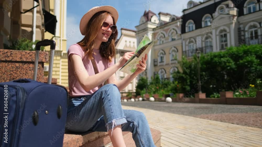 Beautiful Young Woman tourist Pleasant with city map and suitcase sitting on stairs Beautiful Young Woman tourist Pleasant with city map and suitcase sitting on stairs