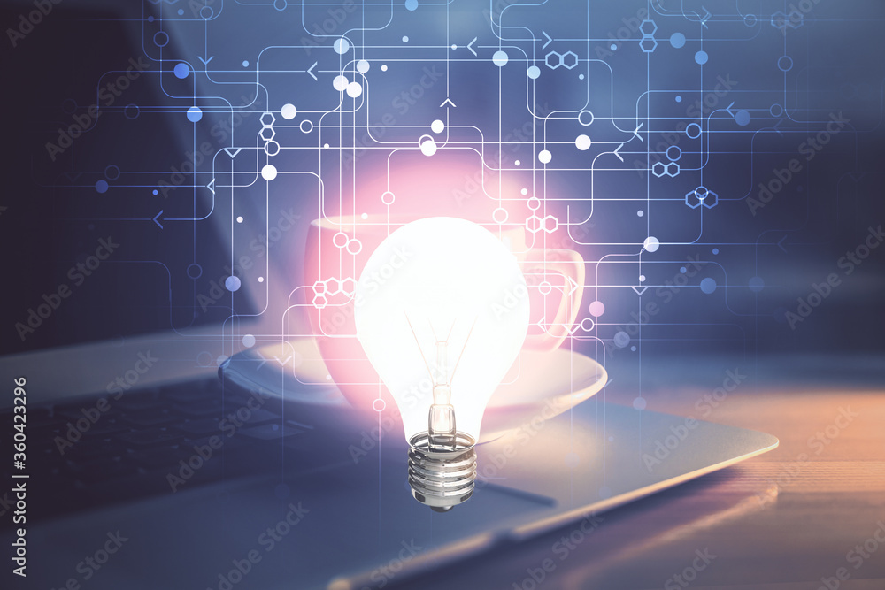 Computer on desktop in office with bulb icon hologram. Double exposure. Concept of idea. Computer on desktop in office with bulb icon hologram. Double exposure. Concept of idea.