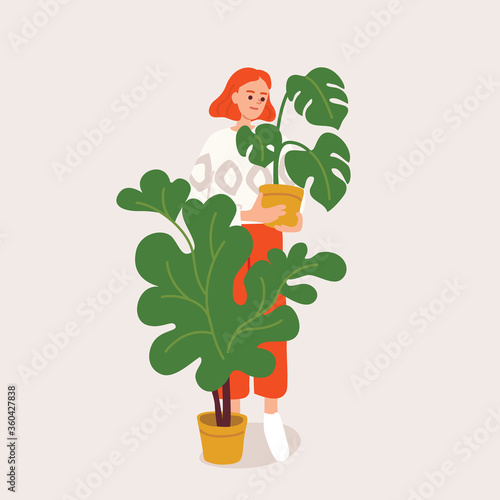 Girl holding monstera plant in a pot. Woman planting flowers.