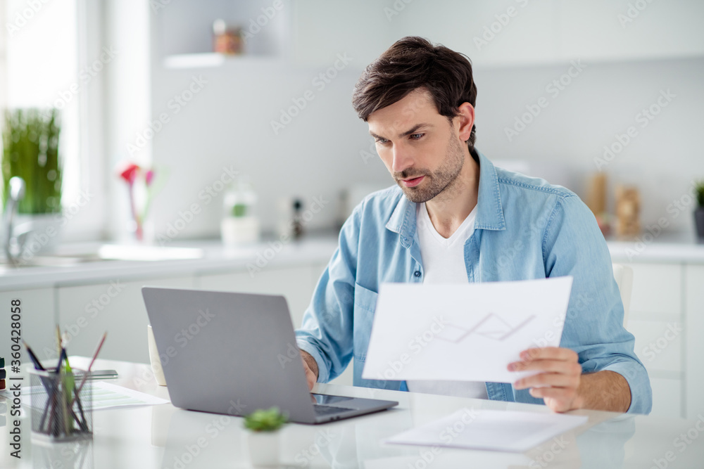 Photo of handsome serious boss guy businessman browsing notebook sitting table read contract check papers work stay home online lesson education webinar skilled teacher quarantine indoors Photo of handsome serious boss guy businessman browsing notebook sitting table read contract check papers work stay home online lesson education webinar skilled teacher quarantine indoors