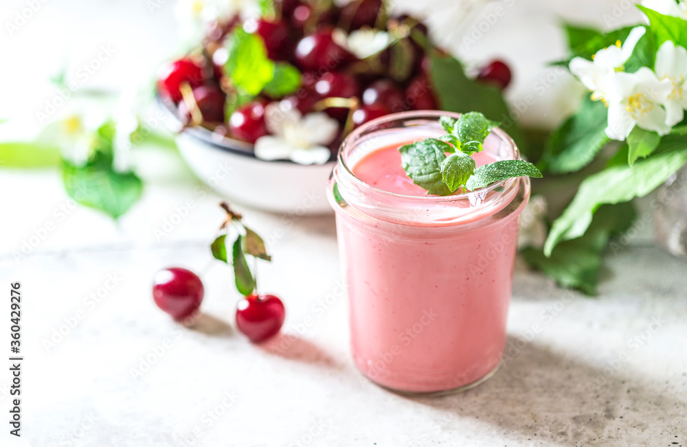 Yogurt with cherry, mint and and fresg berries on a light concrete background. Summer healthy dessert with berries. Yogurt with cherry, mint and and fresg berries on a light concrete background. Summer healthy dessert with berries.