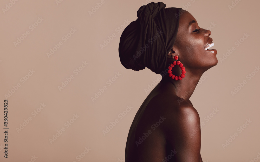 Fashionable african woman smiling on beige background - obrazy, fototapety, plakaty 