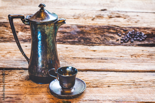 Φωτογραφία Vintage photo a silver coffee pot and a silver espresso cup on wooden table