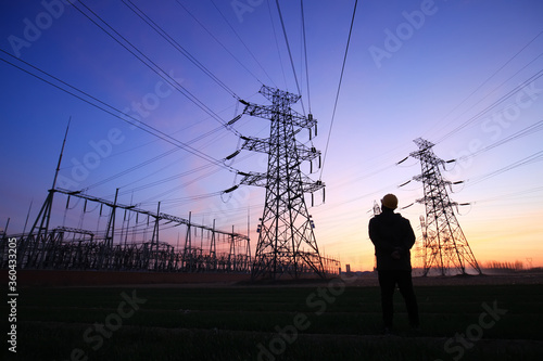 Electricity workers and pylon silhouette, Power workers at work photo